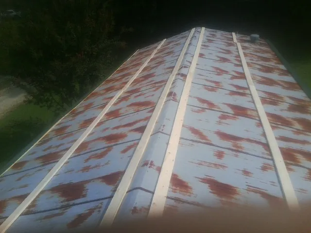 Rusted metal roof panels with new wood purlins before replacement — Storm Damage Roof Repair in Winchendon by Roofing Brothers