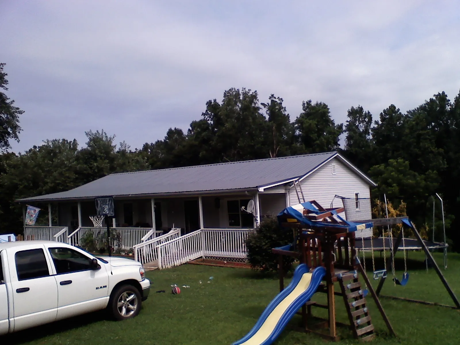 Dark metal roof on a country home with a full length front porch in Winchendon